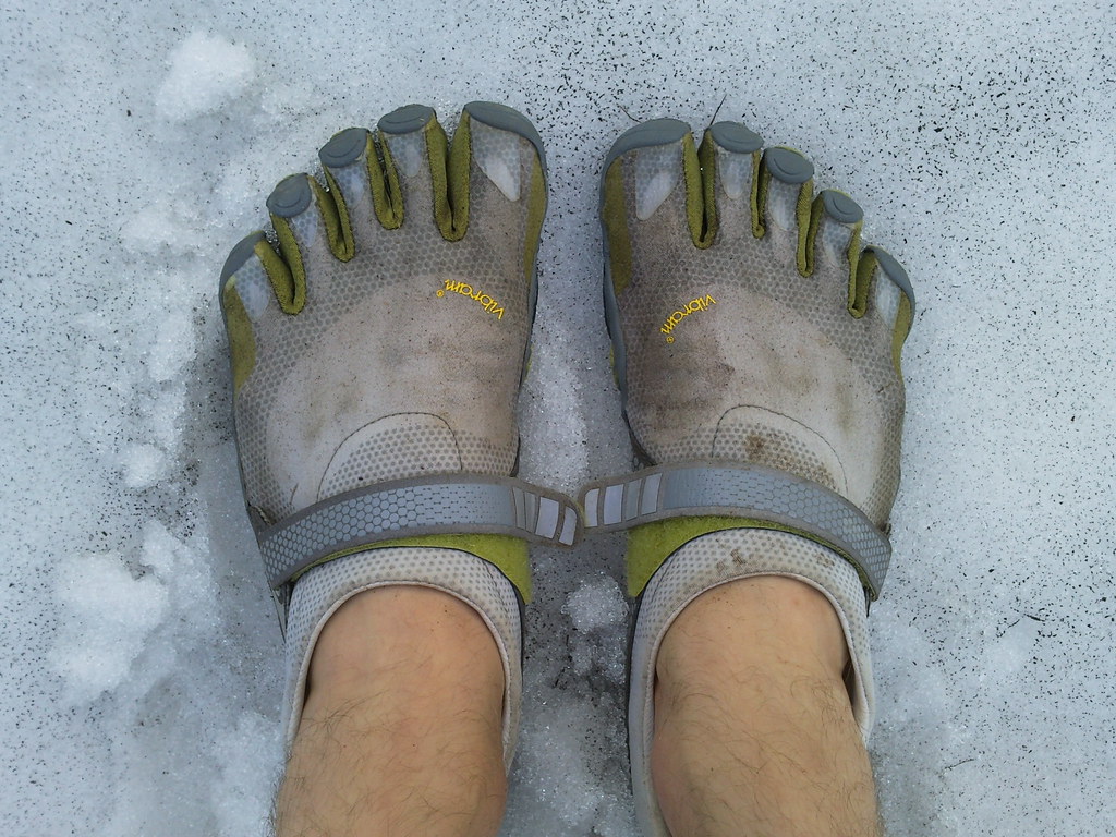 Barefoot-style shoes with separate toe slots on snowy ground