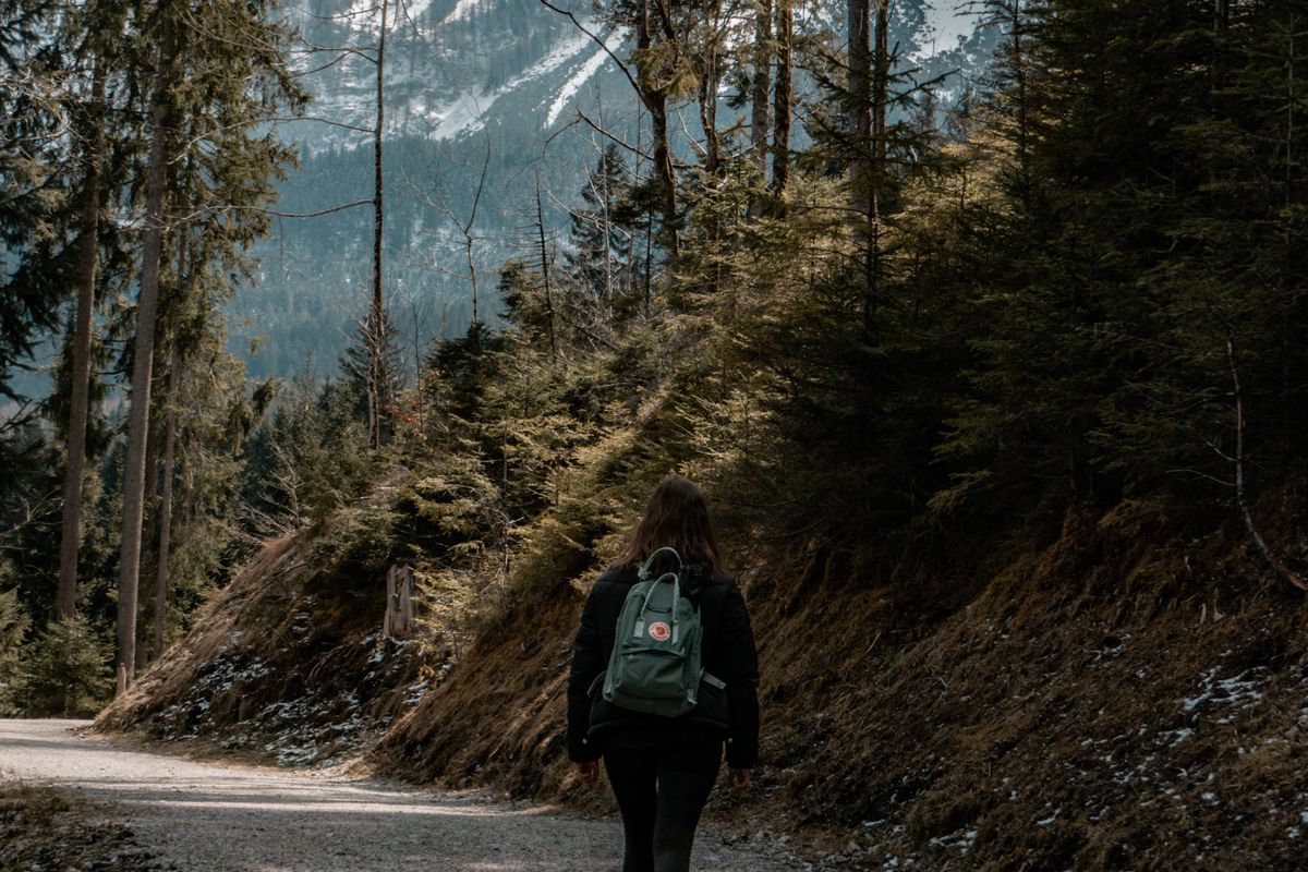 Woman with a backpack hiking along a footpath