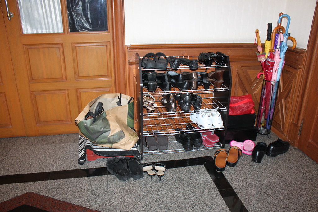 Shoes piled on a crowded shoe rack