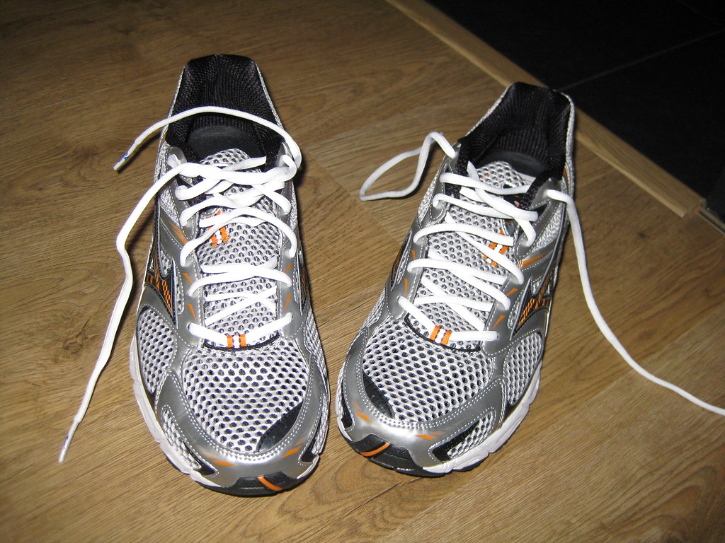 A pair of mesh running shoes on a wooden floor