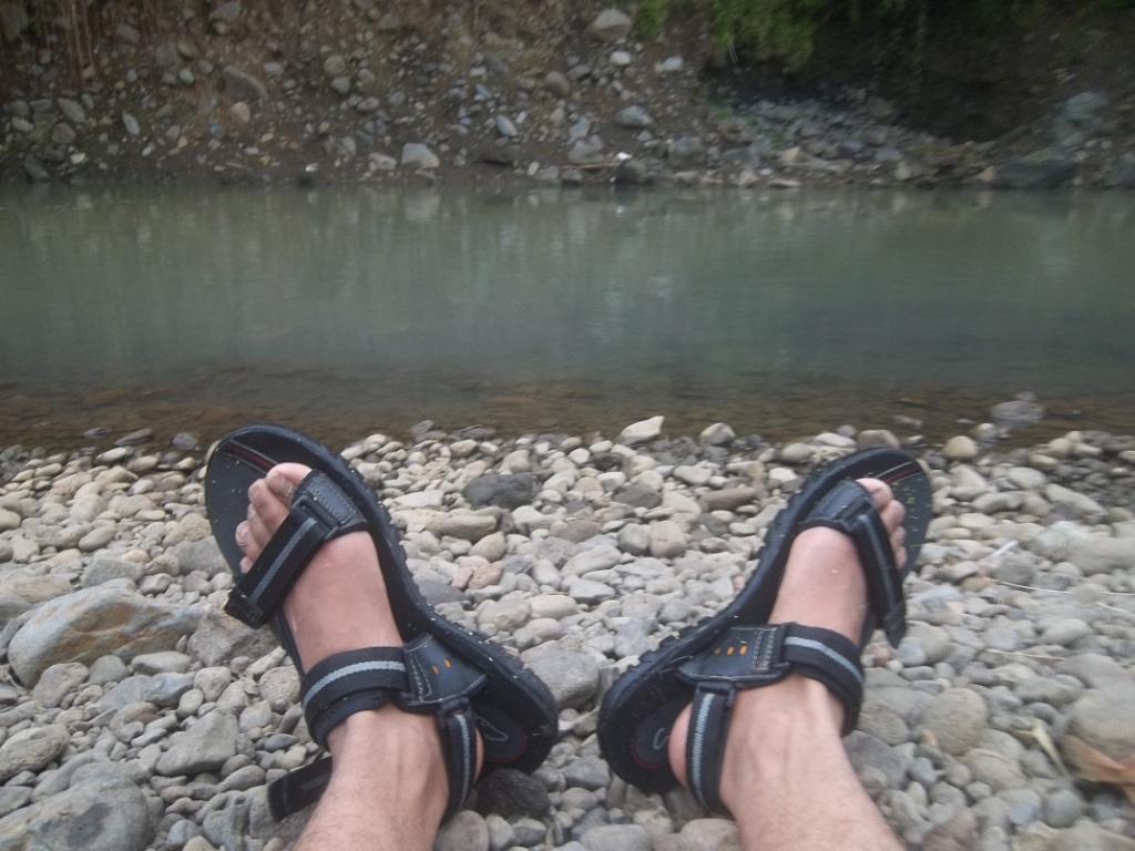 A pair of strappy hiking sandals on rocky ground