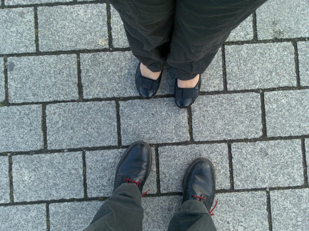 Feet walking across a paved city plaza