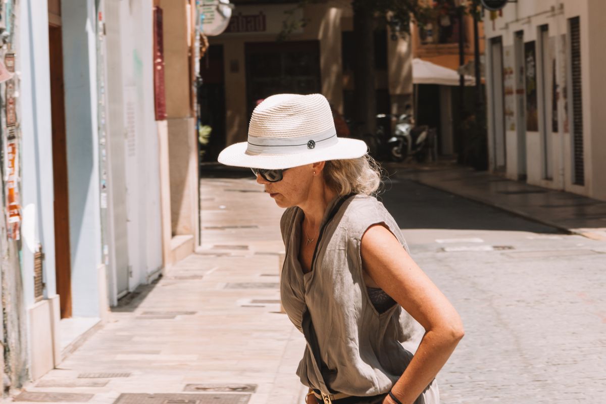 A woman walking through town on a hot summer day