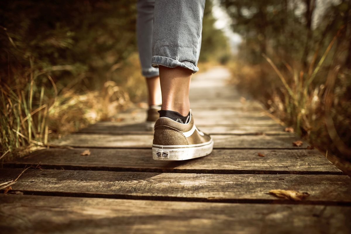 Person standing on a brown walking path
