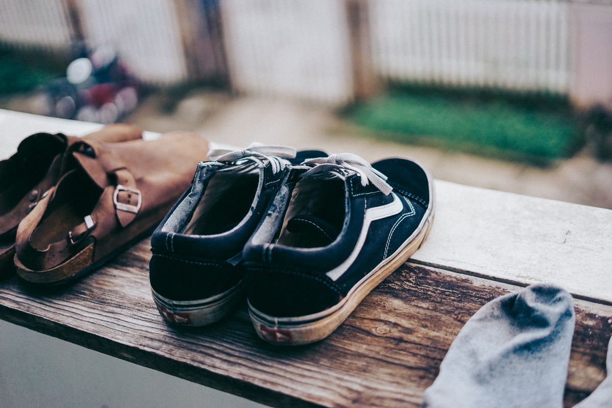 Sneakers drying on a balcony railing in the sun